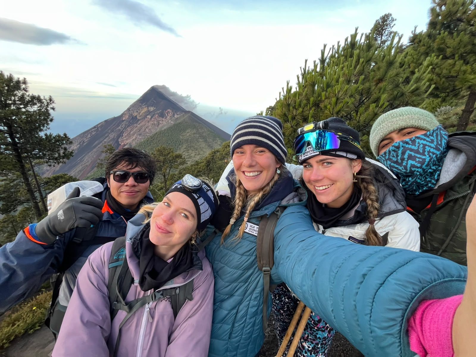 Hikers at Acatenango high camp with Fuego volcano behind them