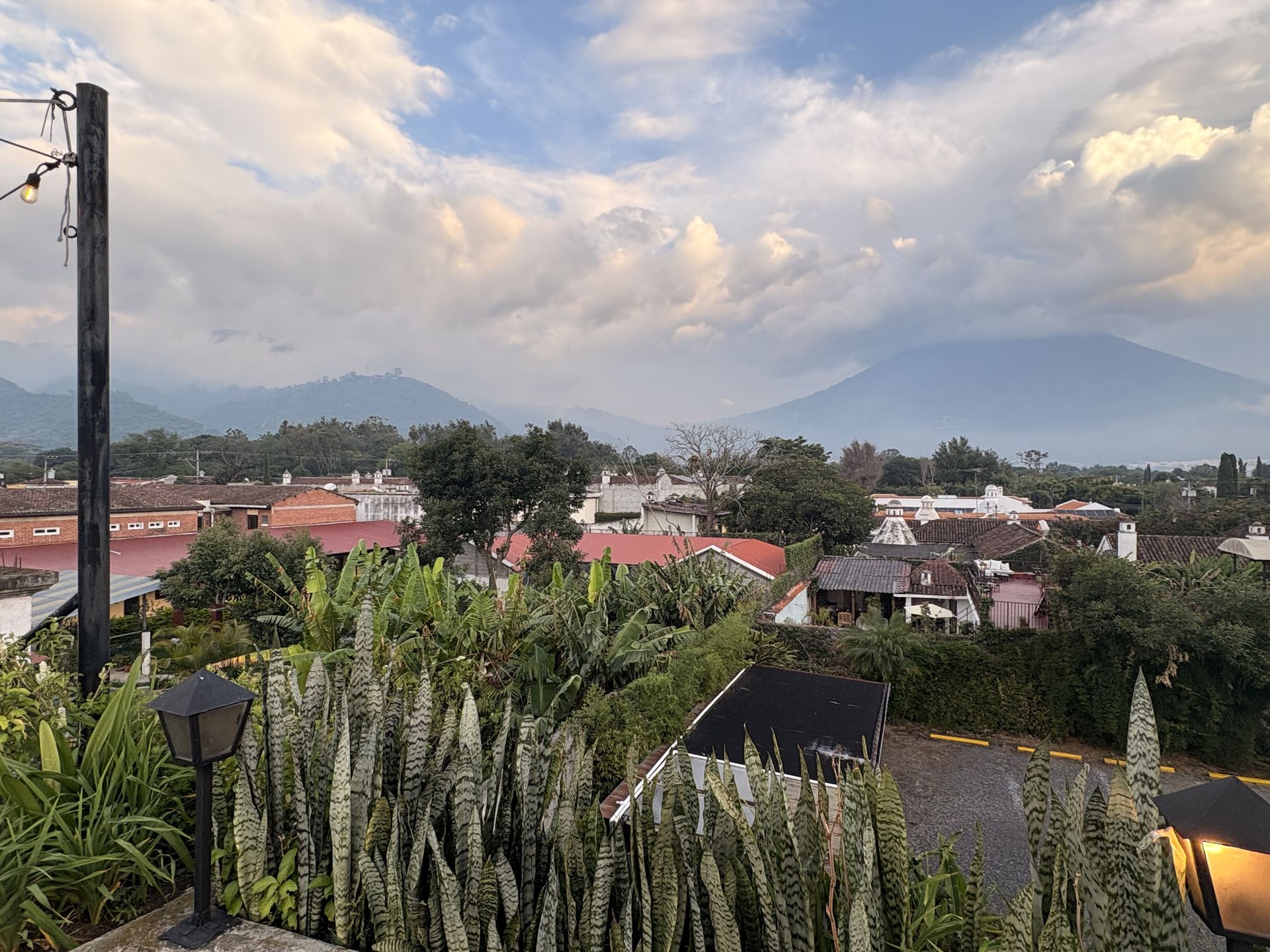 Rooftop panorama over Antigua Guatemala with agave, tiled roofs and the surrounding highlands