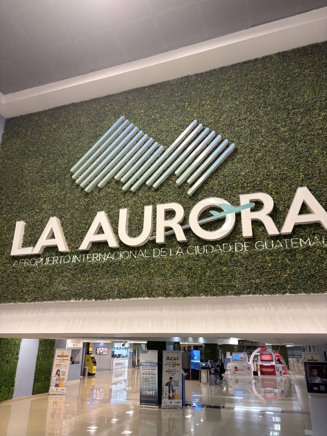 La Aurora airport sign set into a green living wall