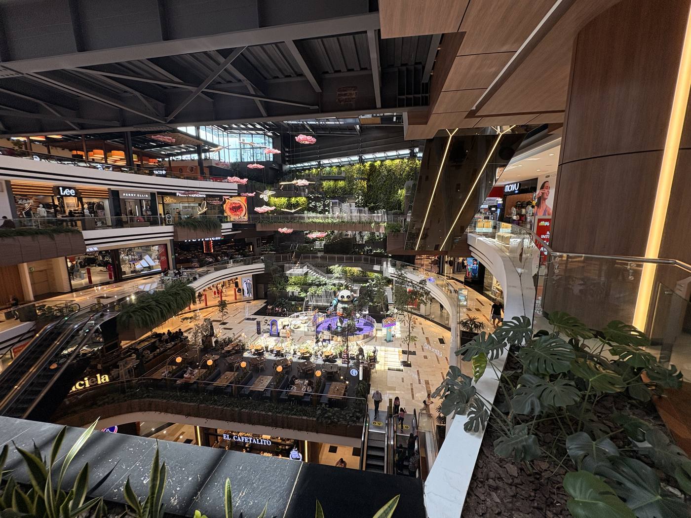Multi-level shopping atrium in Zona 10 with hanging greenery